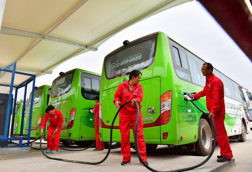 Staff workers charge electric buses at an oil production facility in Puyang, Henan province, in May 2018. [Photo/IC]