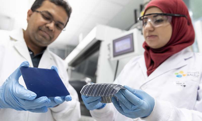 Muhammad Mustafa Hussain (left) and Nazek El-Atab compare the flexibility of their solar cell with the rigid nature of a typical silicon solar cell. Credit: KAUST